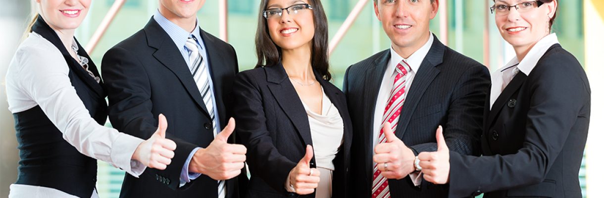 Business – group of businesspeople in office Business - group of businesspeople posing for group photo in office showing thumbs up